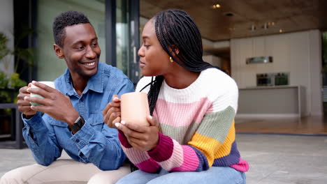 drinking coffee, young african american couple sitting together and relaxing at home