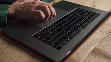 mano de persona irreconocible trabaja en el panel táctil de la computadora portátil