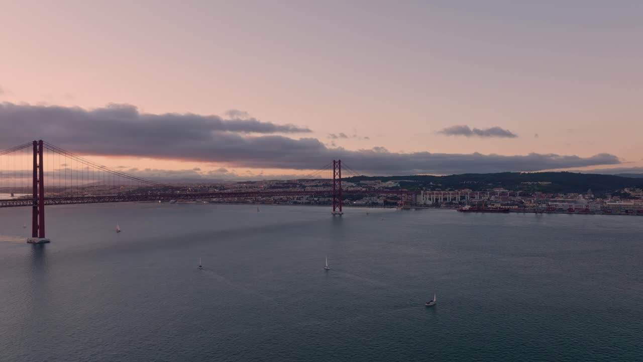 Scatto al tramonto del Ponte 25 Aprile a Lisbona con la città sulla destra