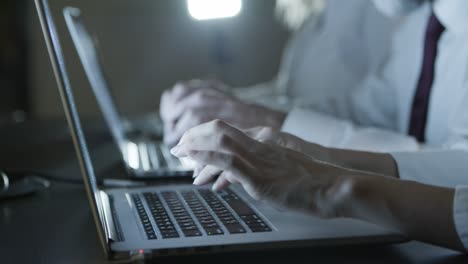 partial view of people typing on laptops