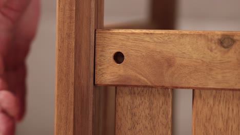 hands carefully align wooden pieces for furniture assembly in a softly lit environment, emphasizing craftsmanship and attention to detail