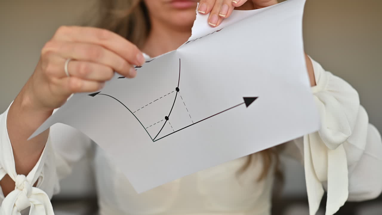 Donna che strappa un pezzo di carta con un grafico sull'inflazione