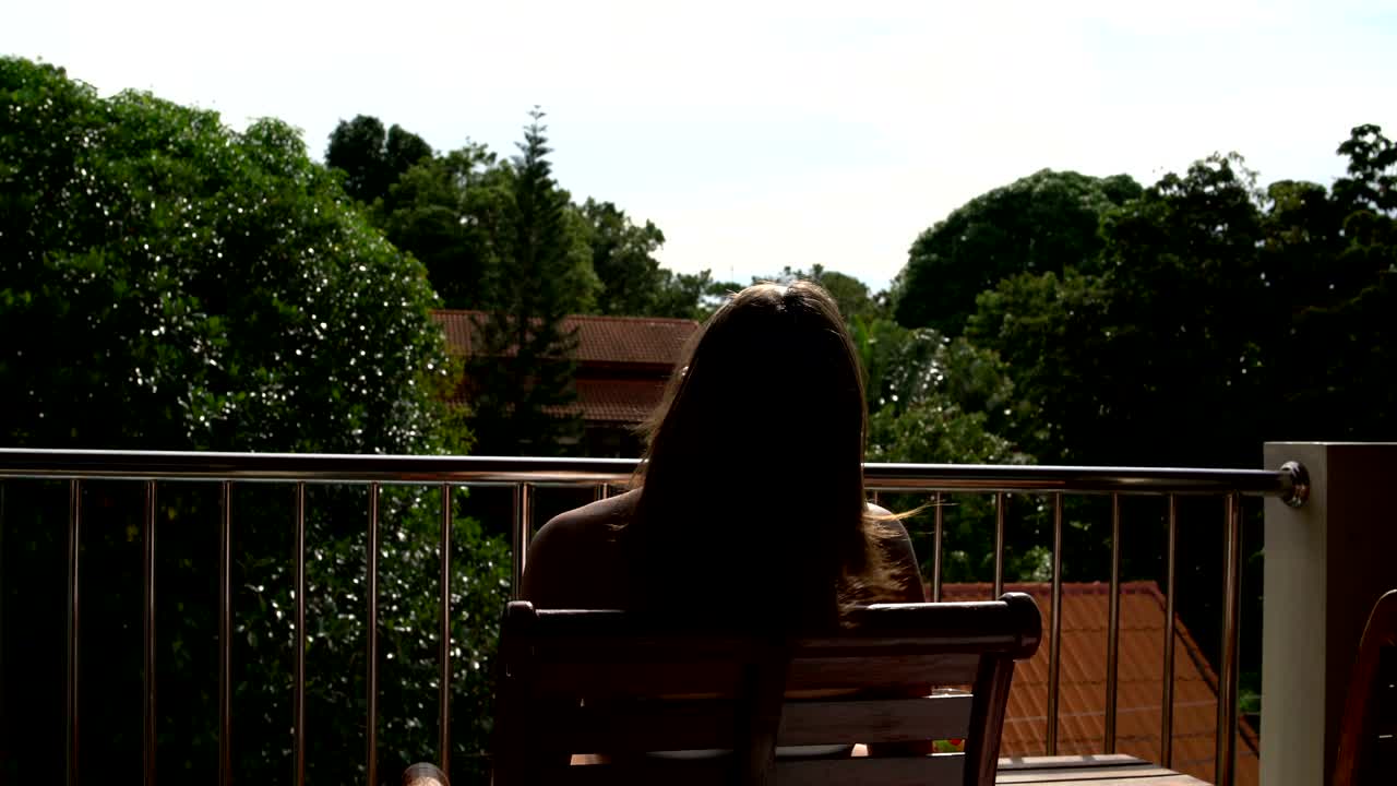 mujer sentada en el balcón del hotel