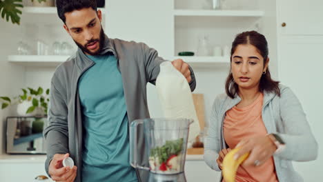 Couple making a healthy smoothie in the kitchen