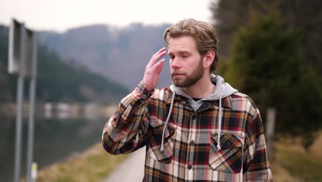 during a walk, a young blond man looks up from the ground and looks very hot to the right