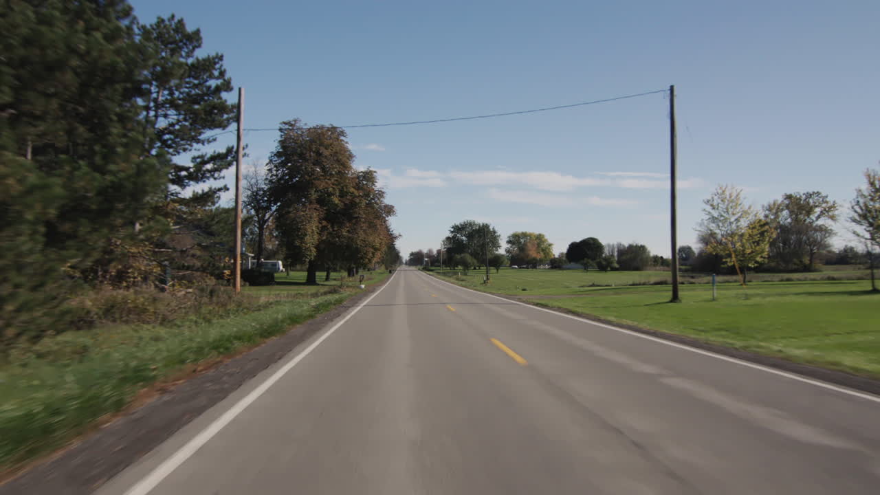 Driving straight on a flat road in a typical American agricultural region. Driver's view