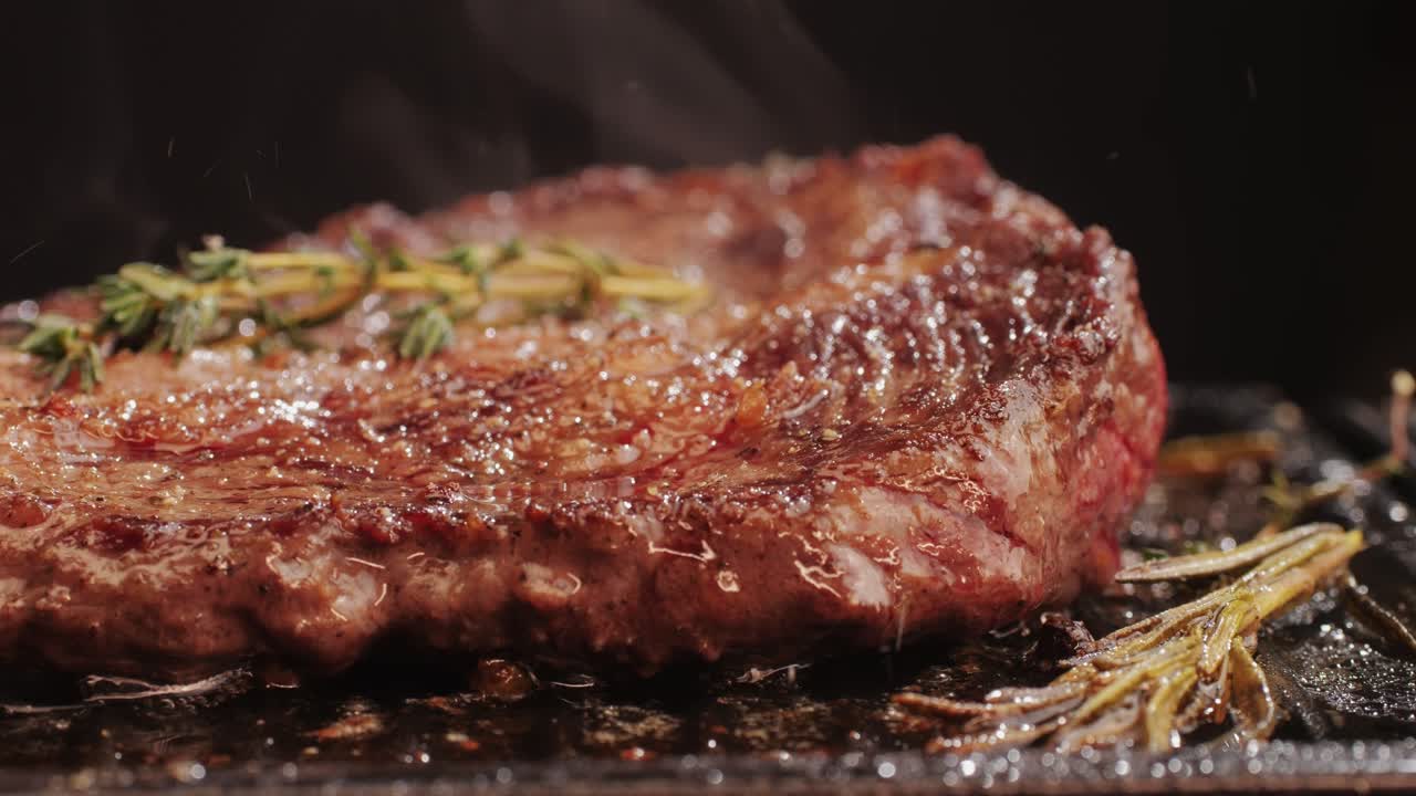 Fresh marbled beef with pepper, salt and rosemary close-up macro. Cooking juicy steak on grill with oil. Premium organic wagyu meat. High quality 4k footage