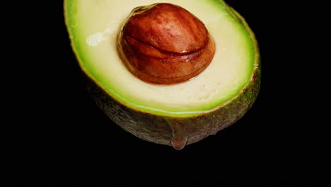 close-up of a cut avocado with dripping oil