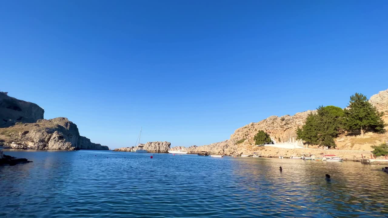 Lindos beach overlooking Acropolis ruins Castle in Rhodos, Greece, travel destination filmed in 4K during the day
