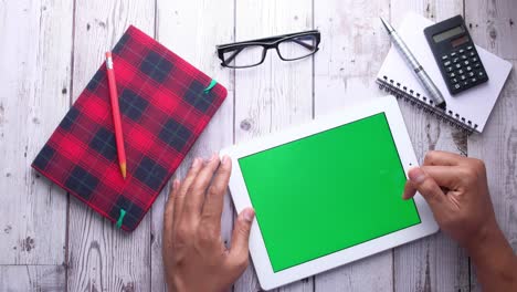tablet with green screen on wooden desk