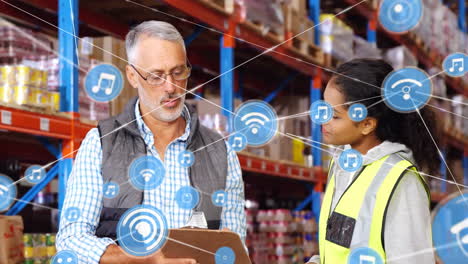 Animation-of-network-of-connections-with-icons-over-diverse-workers-talking-in-warehouse