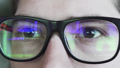 green coding or hacking text is reflecting in the glasses static shot