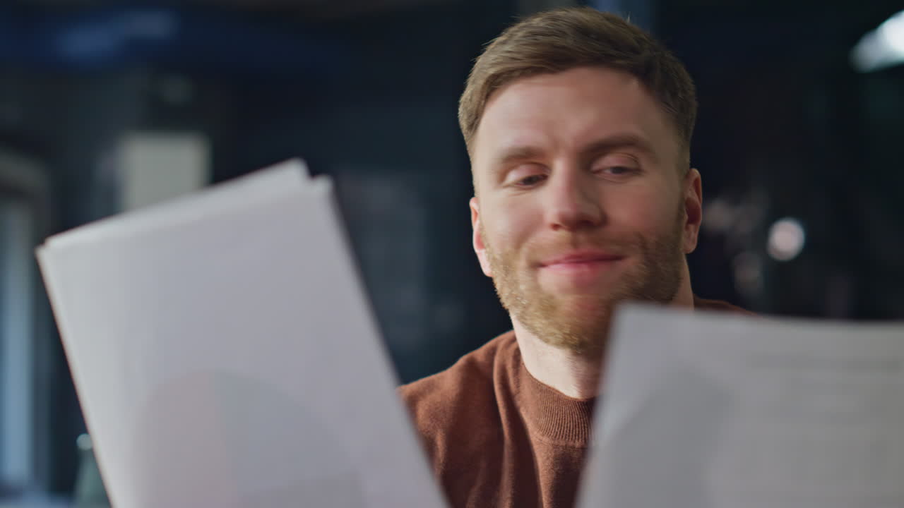 Professional accountant reviewing documents at office desk closeup. Smiling man