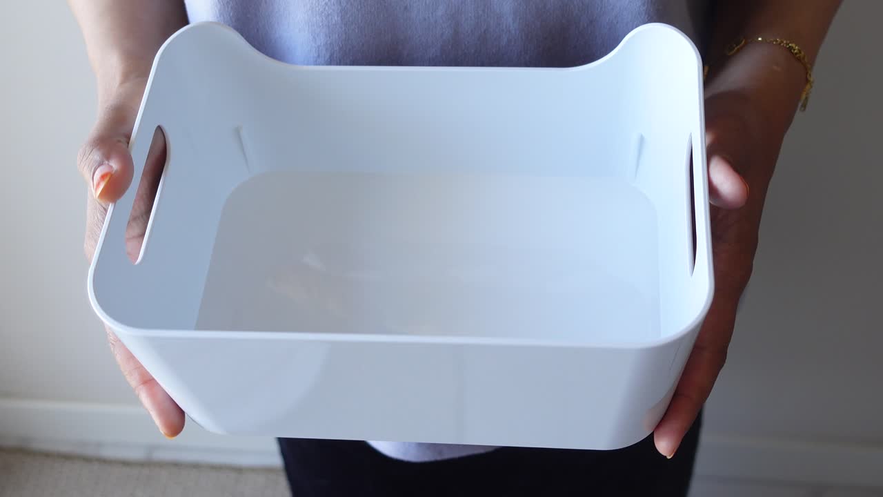 Empty White Plastic Storage Box Held in Hands