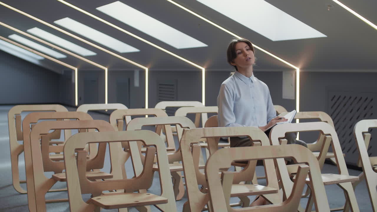 молодая белая женщина задает вопрос во время лекции