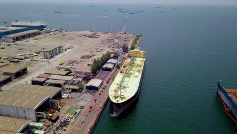 Aerial-view-of-logistics-concept-of-commercial-vehicles,-cars-and-pickup-trucks-waiting-to-be-load-on-to-a-roll-on-roll-off-car-carrier-ship