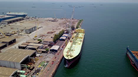 aerial view of logistics concept of commercial vehicles, cars and pickup trucks waiting to be load on to a roll-on-roll-off car carrier ship