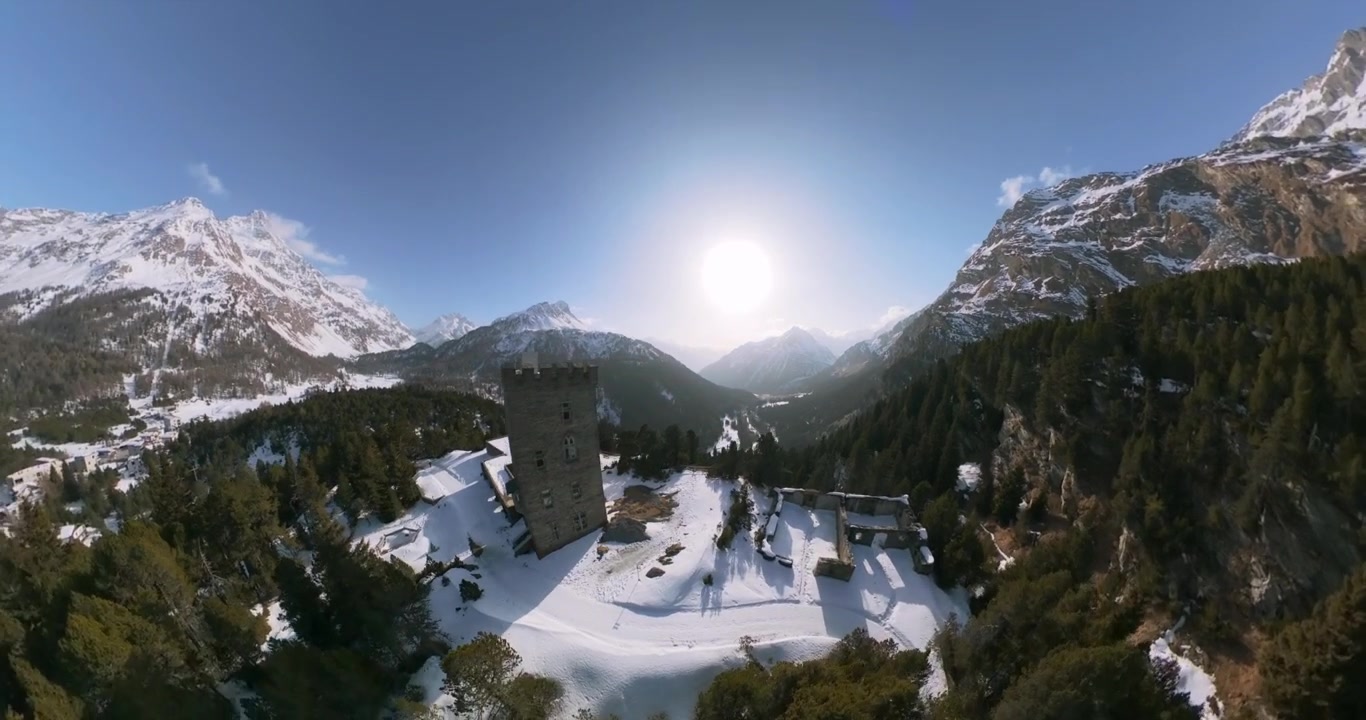 Torre Belvedere e rovine del castello su una cresta innevata, montagne nel Passo del Maloja, Svizzera. Drone aereo grandangolare in orbita, spazio per il testo