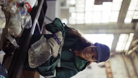 Afro-american-girl-sorting-bottles-at-a-garbage-recycling-plant.-Pollution-control