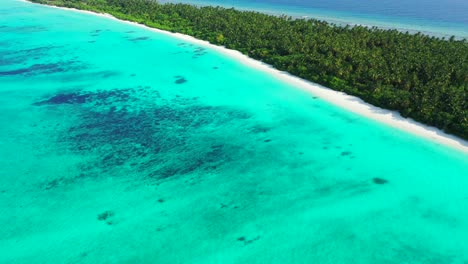 Bright-wide-turquoise-lagoon-with-wonderful-pattern-of-coral-reefs-around-tropical-island-with-lush-vegetation-in-Atlantic-ocean,-copy-space