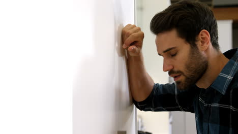 el hombre está de pie con una expresión triste en su cara