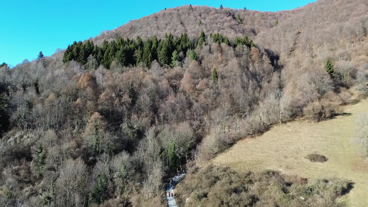 Cinematic drone footage of the Dolomites, with snowy mountains rising into a clear blue winter sky. beautiful greens