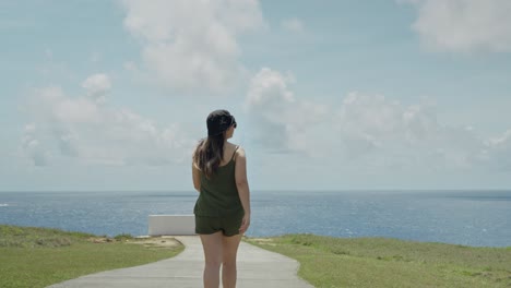 Girl-walking-to-the-end-of-the-cliff-and-looking-out-to-the-sea