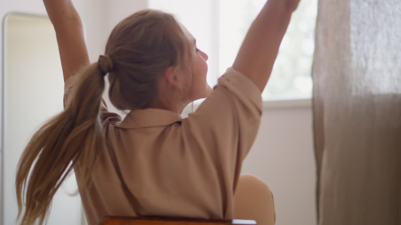 mujer feliz con cola de caballo gira en la silla en el vestidor