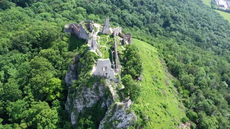 flight above the abandoned and ruined medieval plavecky castle on a rock, slovakia