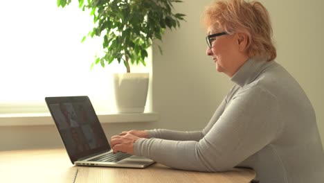 Head-shot-mature-woman-looking-at-camera-and-talking,-grandmother-chatting-with-relative-online,-making-video-call,-middle-aged-blogger-recording-vlog,-teacher-speaking-to-webcam,-distance-lecture