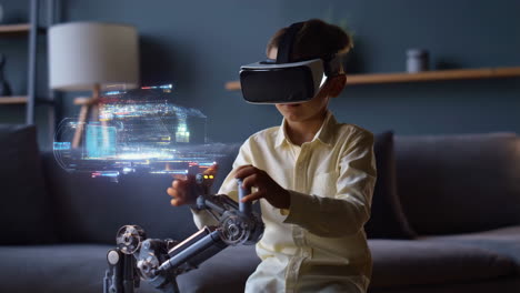 young boy interacting with virtual reality, robotic arm, and holographic display at home