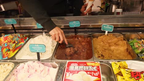 hand scooping chocolate tiramisu ice cream