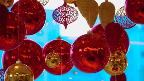 christmas and new year decoration. christmas big red balls on  background of luminous lanterns and gold garlands. holiday background. blinking garland. red baubles with lights twinkling close up.