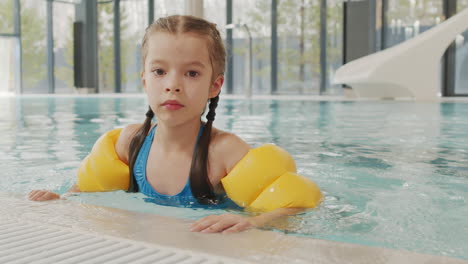 young girl swimming in indoor pool