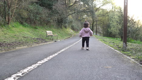 Rückansicht-Eines-Kleinkindes,-Das-Auf-Einem-Asphaltweg-Im-Park-Läuft