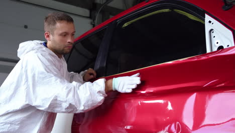 car wrap installation by a worker in a garage