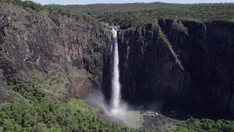 woman standing on the observation deck looking at wallaman falls in girringun national park, qld, australia - aerial forward