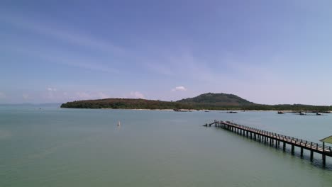 Laem-Hin-Pier-in-tropical-andaman-sea-with-coconut-island-on-horizon-in-thailand,-aerial