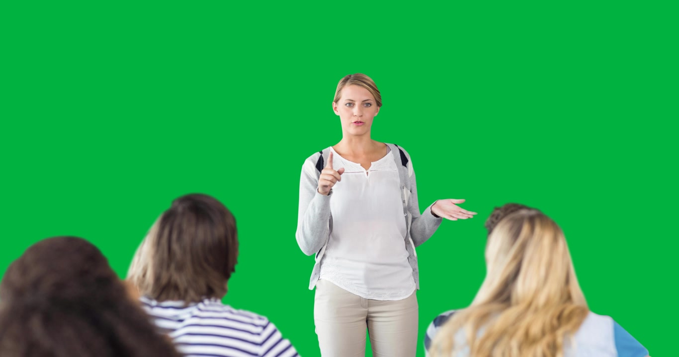 Insegnante donna caucasica che insegna a un gruppo di studenti su sfondo nero.