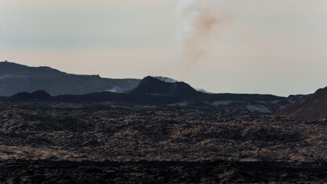 Rauch-Steigt-Vom-Vulkan-Grindavik-Vor-Einer-Kargen,-öden-Landschaft-In-Der-Abenddämmerung-Auf