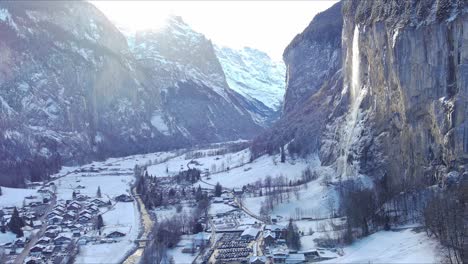 moving towards mountainside over snowy village | lauterbrunnen switzerland, swiss valley in alps drone, europe, 4k