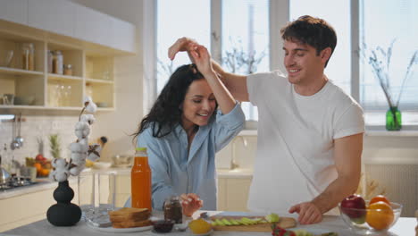 wife tasting breakfast husband on kitchen close up. happy couple eating apple.