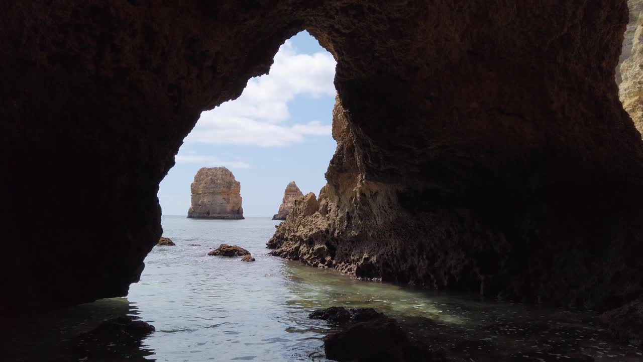 mirando desde la boca de una cueva marina del algarve hasta una pila de roca caliza, portugal