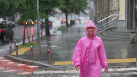 woman in pink raincoat walking in the rain