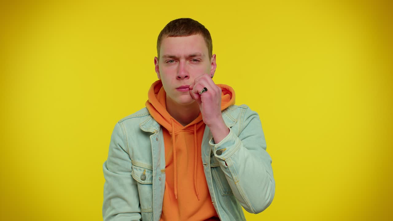 Muž si přikládá ukazováček na rty, dělá gesto ticha, aby nevyzradil tajemství, psst, buďte zticha