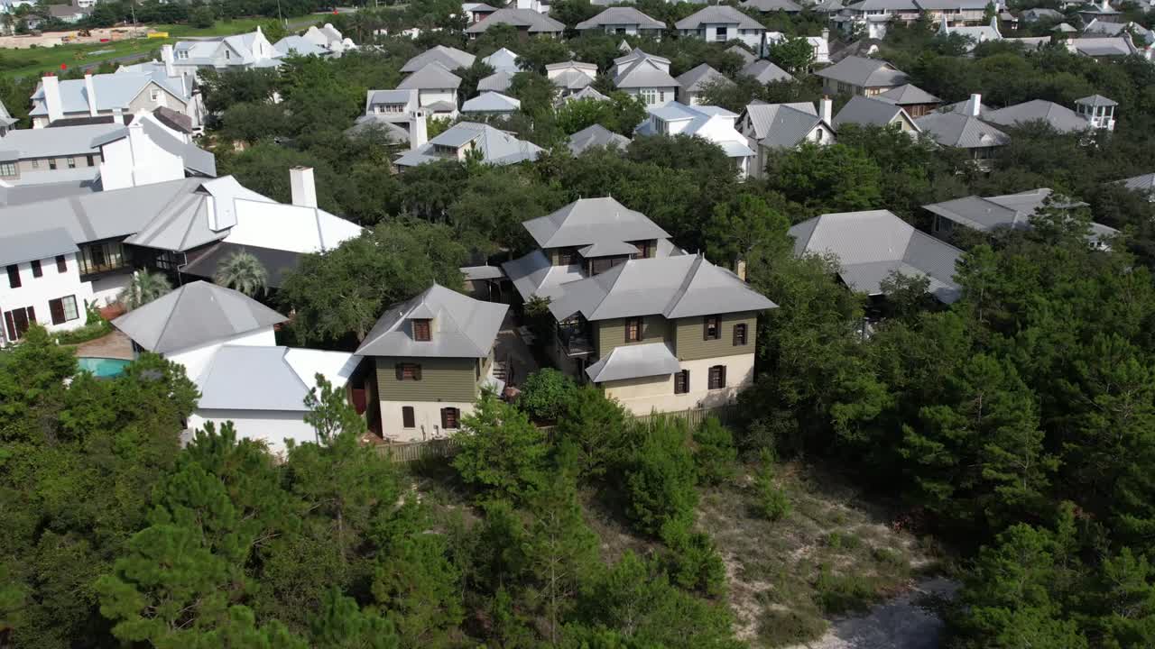Village Houses Surrounded With Lush Green Foliage Rosemary Beach, Walton County, Florida. aerial drone tilt down
