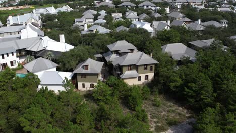 village houses surrounded with lush green foliage rosemary beach, walton county, florida. aerial drone tilt down