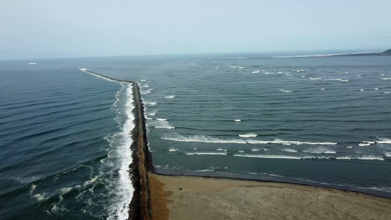 US, Oregon, Astoria, Fort Stevens, 2025-03-21 - Drone view of the northwest tip of Oregon where the Columbia River meets the Pacific Ocean. The jetty protects the river entrance.