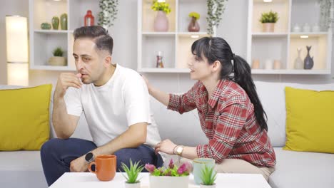 his wife comforts the man who is nervous at home.