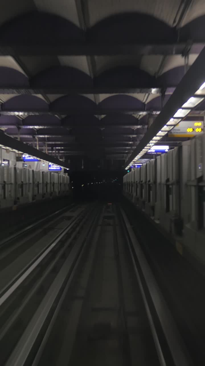 POV di un treno che arriva in una stazione della metropolitana sotterranea buia